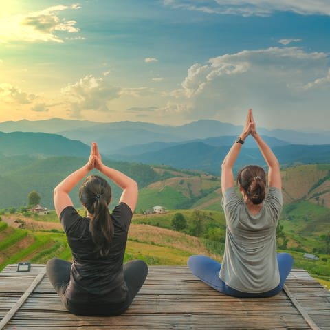 Zwei Frauen beim Yoga mit Blick auf die Berge (Foto: Colourbox)