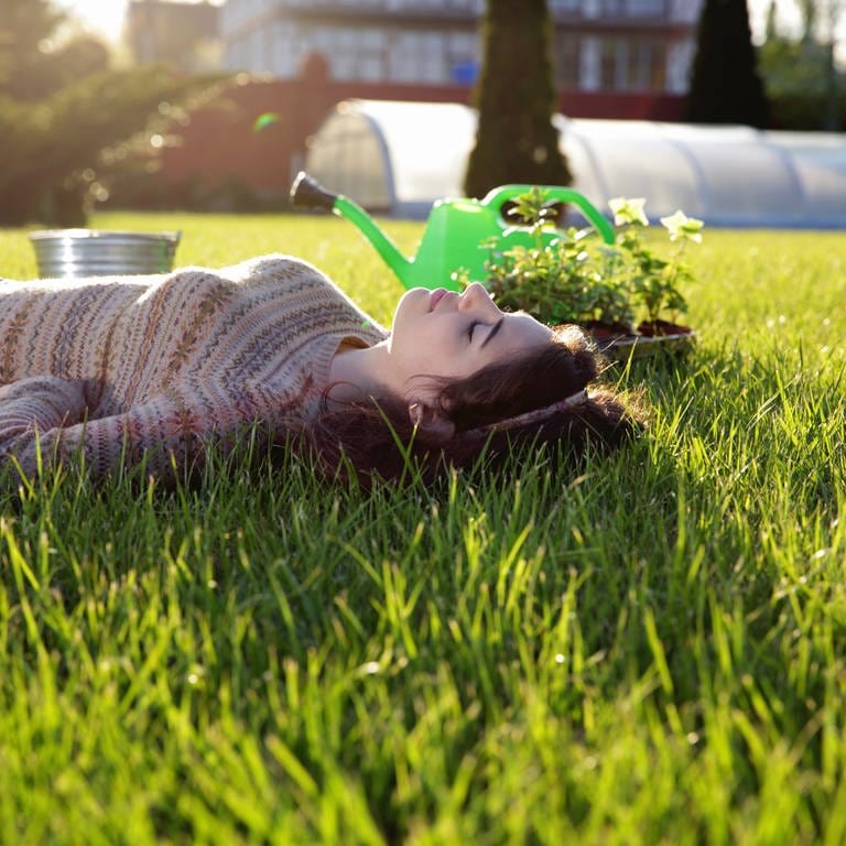 Frau liegt im Rasen (Foto: Colourbox)