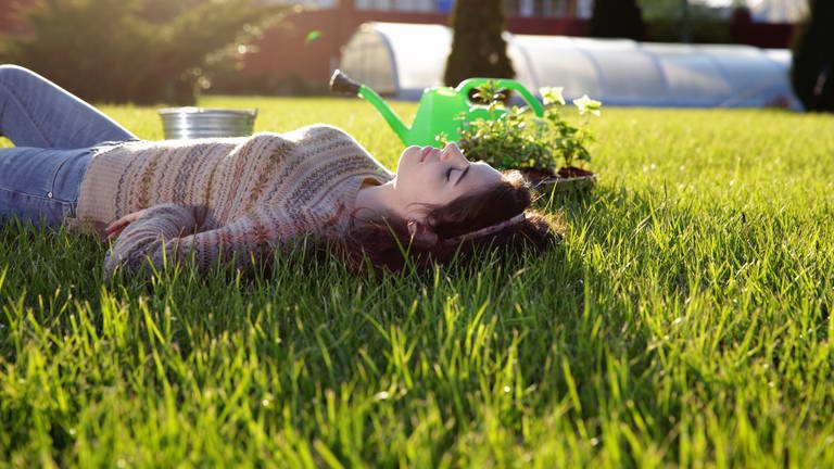 Frau liegt im Rasen (Foto: Colourbox)