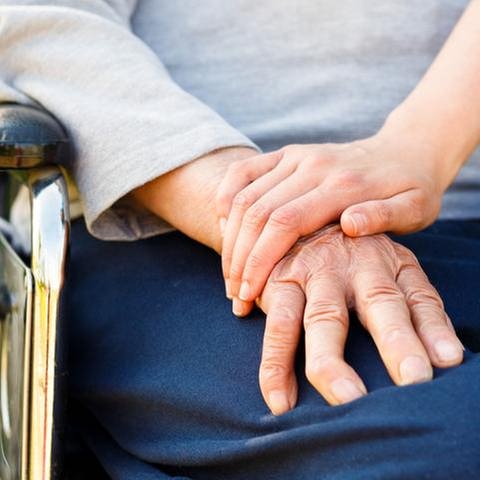 Eine junge Hand hält die Hand einer älteren Person im Rollstuhl. (Foto: Colourbox, Foto: Colourbox.de -)