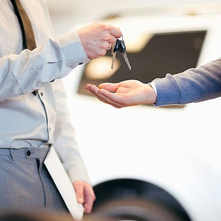 Ein Autoverkäufer übergibt einem Kunden einen Autoschlüssel. (Foto: Getty Images, Thinkstock -)