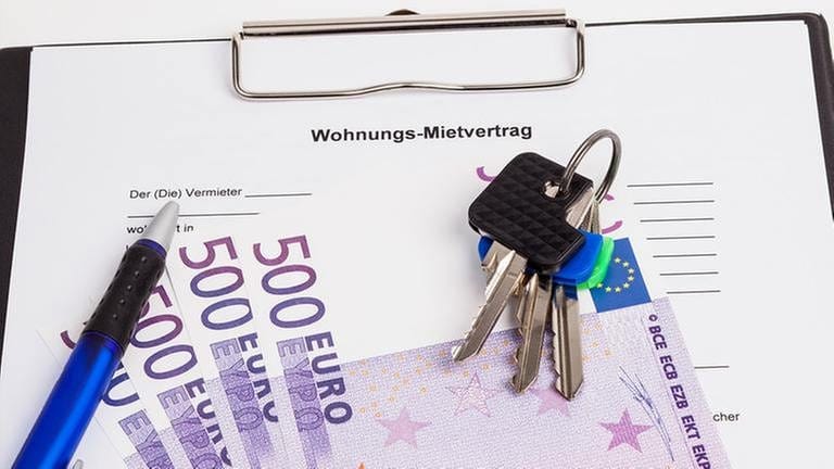 Wohnungs-Mietvertrag mit Schlüssel, Stift und mehreren 500 Euro Scheinen.