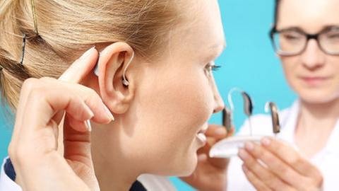 Frau kriegt ein passendes Hörgerät von einer Ärztin (Foto: Getty Images, Thinkstock -)