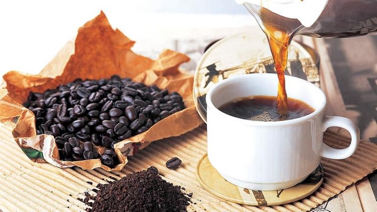 Eine Tasse mit Kaffee daneben Kaffeebohnen (Foto: Getty Images, Thinkstock -)