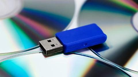 Ein USB-Stick liegt auf spiegelnden Daten-CDs. (Foto: Getty Images, Thinkstock -)