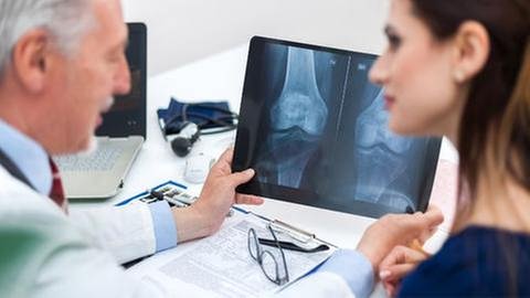 Eine Arzt erklärt einer Frau ein Röntgenbild. (Foto: Getty Images, Thinkstock -)