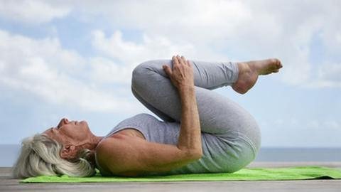 ältere Frau zieht die Beine bei einer Yoga-Übung an (Foto: Colourbox, Model Foto: Colourbox.de -)