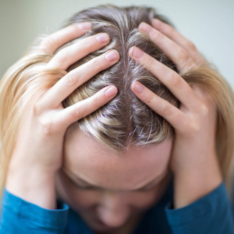 Ängste und Depression: Frau schlägt Hände über den Kopf