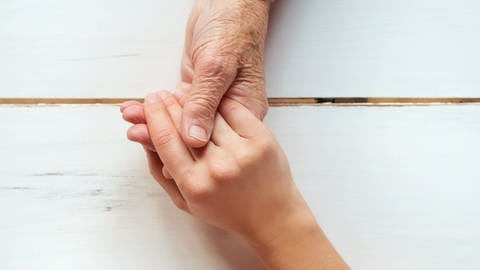 Junge Frau hält älterer Frau die Hand (Foto: Colourbox)