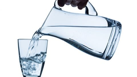 Bei Hitze viel trinken: Wasser wird aus Karaffe in Glas eingeschenkt (Foto: Colourbox, Erwin Wodicka - wodicka@aon.at)