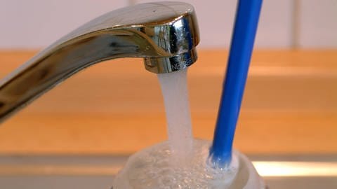 Kunststoff-Trinkflasche wird unter fließendem Wasser gereinigt