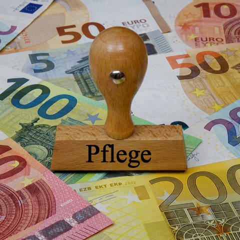 Stempel mit Aufschrift Pflege auf Geldscheinen (Foto: IMAGO, Sascha Steinach via www.imago-images.de)