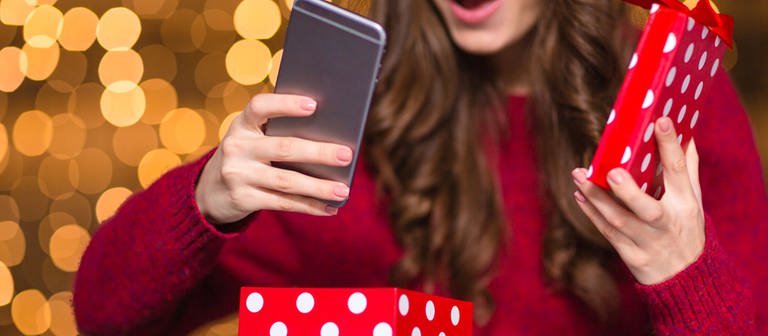 Frau packt Weihnachtsgeschenk Smartphone aus (Foto: Colourbox)
