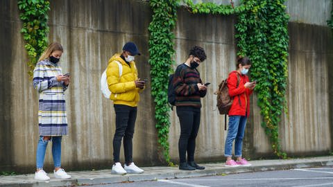 Smartphones Datenübertragen: Vier junge Menschen am Telefon (Foto: Colourbox)