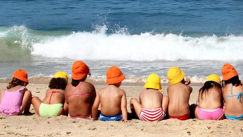 Urlaub am Meer: Kinder sitzen am Strand (Foto: Colourbox)