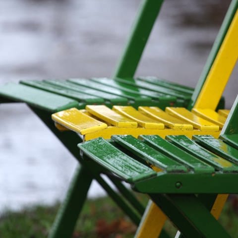 Bunte Holzstühle stehen im Regen (Foto: Colourbox)