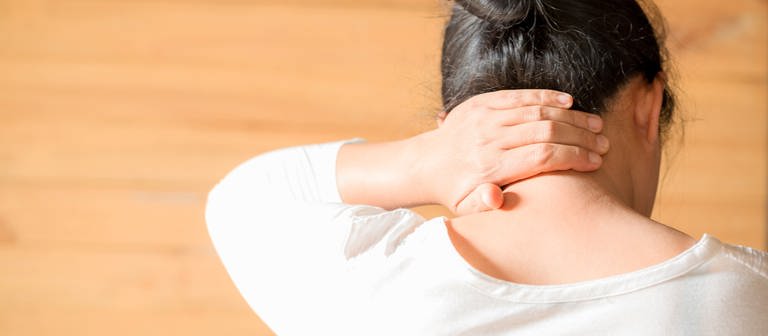 Frau mit Schmerz im Nacken - unsere Übungen helfen, auch für Schmerzen im Kopf (Foto: Colourbox)