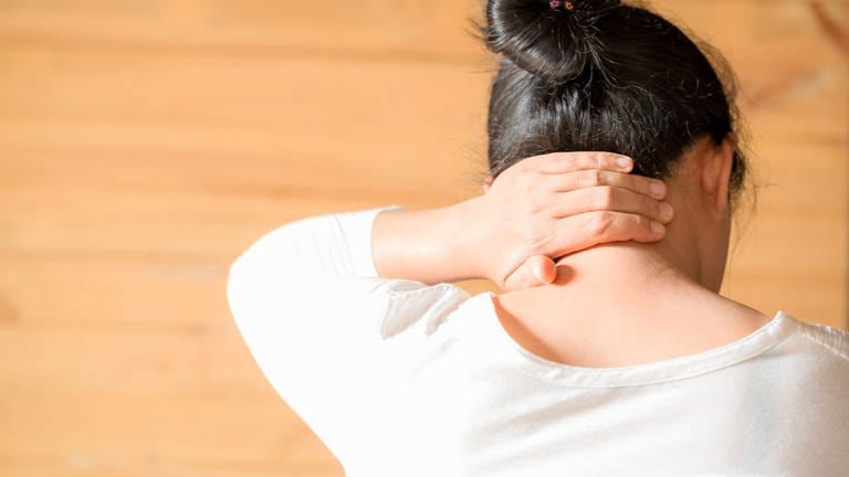 Frau mit Schmerz im Nacken - unsere Übungen helfen, auch für Schmerzen im Kopf (Foto: Colourbox)