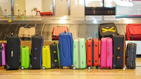 bunte Koffer vor Gepäckband (Foto: IMAGO, IMAGO / Stefan Zeitz)