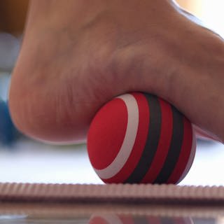 Fitnessübung Füße rollen über einen Ball (Foto: Colourbox)