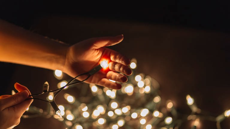 Hand mit Lichterkette - die richtige Weihnachtsbeleuchtung (Foto: Colourbox, getangelstudios)