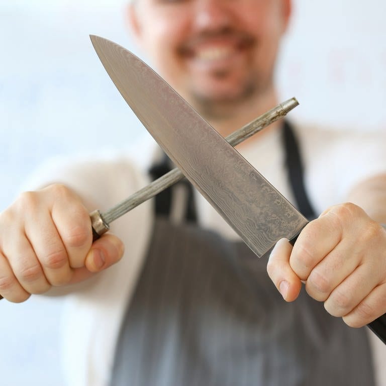 Mann beim Schärfen von Messer (Foto: Colourbox)