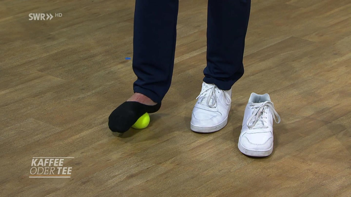 Mann rollt seinen Fuß über einen Tennisball. (Foto: SWR)