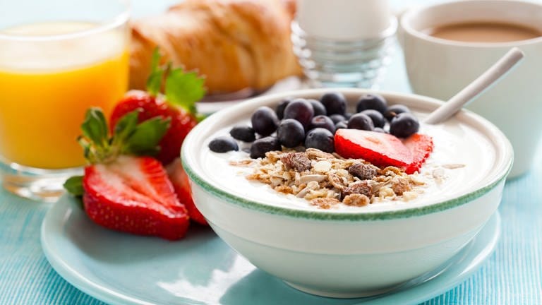 Frühstück mit Obst, Müsli, Joghurt, Ei und Kaffee