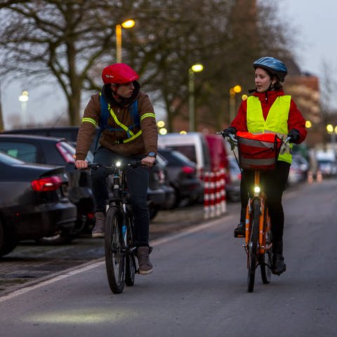 Zwei Fahrradfahrer fahren im Dunkeln mit Licht und gut sichtbarer Kleidung (Foto: IMAGO, Bildnummer: 0069105909)