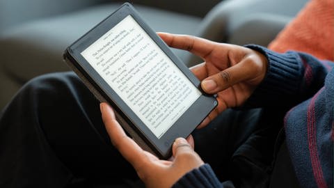 Mann liest auf E-Reader: Online Bücher ausleihen (Foto: IMAGO, IMAGO/Graeme Roy)