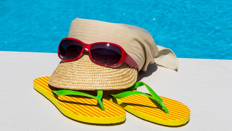 Sonnenbrille mit Strohut am Schwimmbad - Schutz vor UV-Strahlen