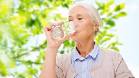 Frau trinkt Wasser aus Glas - egal ob aus Leitung oder Flasche