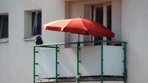 Roter Sonnenschirm auf dem Balkon  Sommer  reinigen