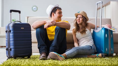 Mann und Frau mit einem Koffer - wer eine Reise macht, braucht Schutz im Ausland