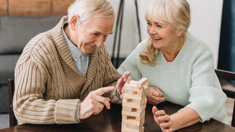 Älterer Mann und Frau spielen - Hilfe gegen Demenz durch die richtige Pflege