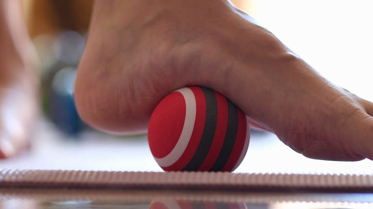 Fitnessübung Füße rollen über einen Ball (Foto: Colourbox)