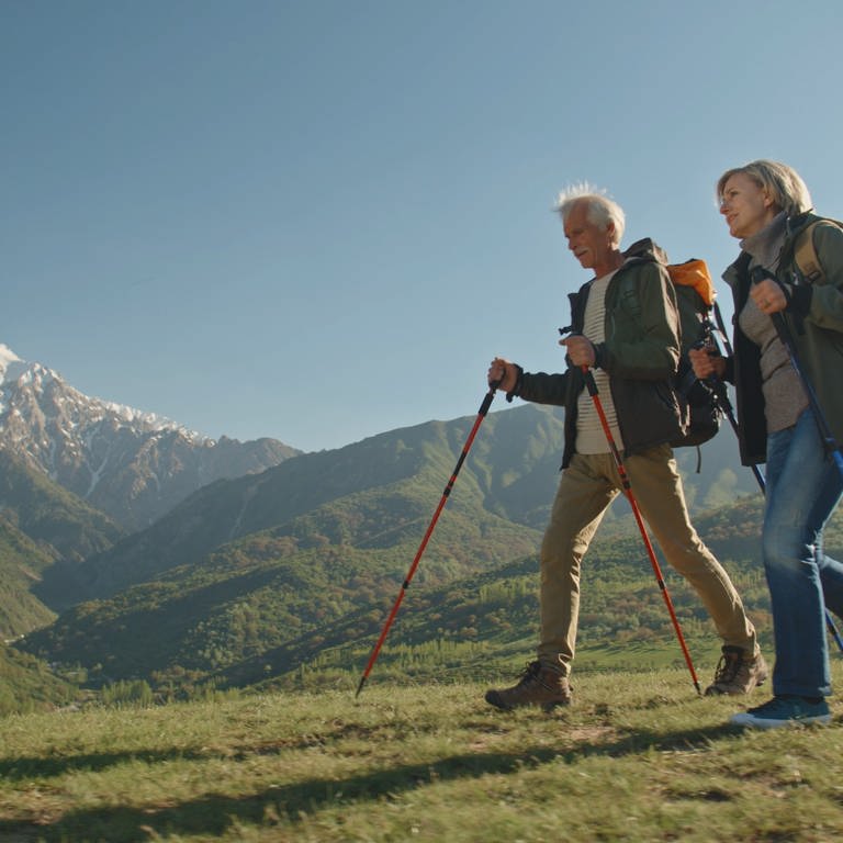 Mann und Frau beim Nordic Walking - Fitness in den Bergen