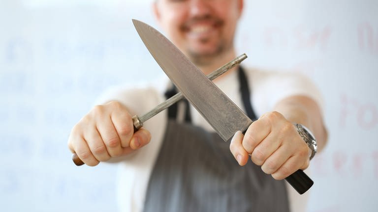 Mann beim Schärfen von Messer