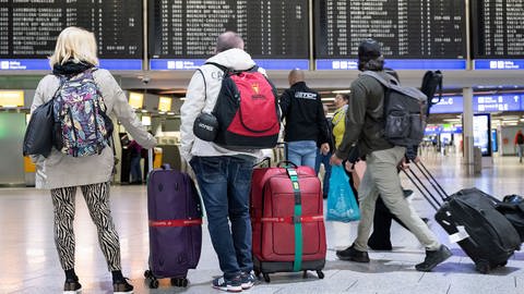 Menschen mit Reisegepäck und Koffer am Flughafen