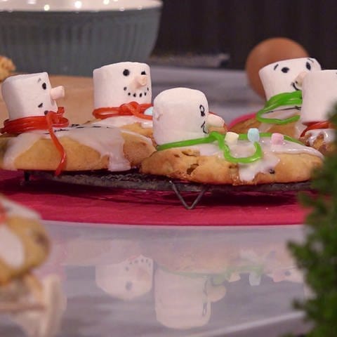 Schneemann-Cookies angerichtet auf Servierplatte in weihnachtlichem Arrangement (Foto: SWR)