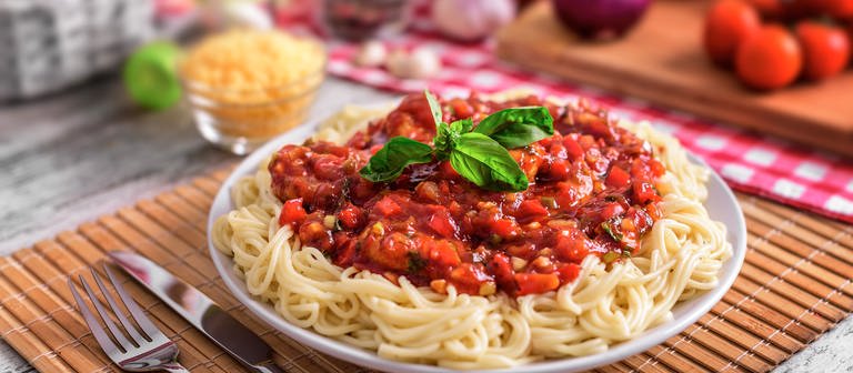 Teller mit Spaghetti Bolognese und Gemüse drum herum (Foto: Colourbox)
