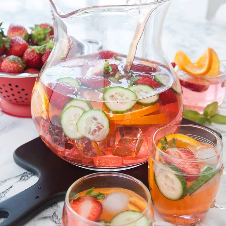 Bowlebehälter mit Gläsern mit Erdbeeren, Orange und Gurke