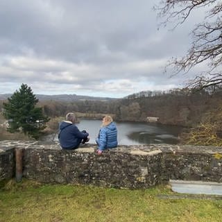 Ausflugs-Reporter Markus Bundt und eine Dame auf Felsenmauer sitzend (Foto: SWR)