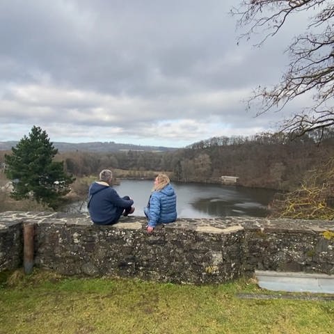 Ausflugs-Reporter Markus Bundt und eine Dame auf Felsenmauer sitzend