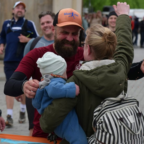 Marathonläufer Simon Fischer umarmt Frau und Kind