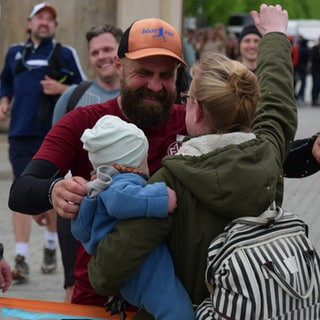 Marathonläufer Simon Fischer umarmt Frau und Kind (Foto: SWR, SWR)