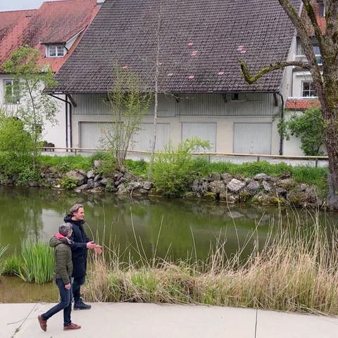 Ausflugsreporter Marius Zimmermann und ein Herr laufen auf der Landesgartenschau in Wangen im Allgäu