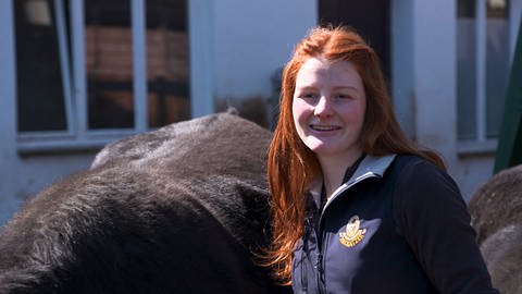 Betriebshelferin Chiara steht neben einer Kuh (Foto: SWR)