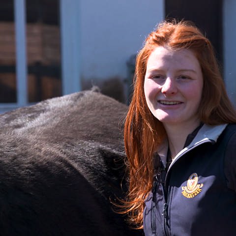 Betriebshelferin Chiara steht neben einer Kuh (Foto: SWR)