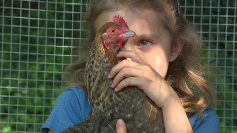 Ein Mädchen hält ein Huhn in den Händen (Foto: SWR)